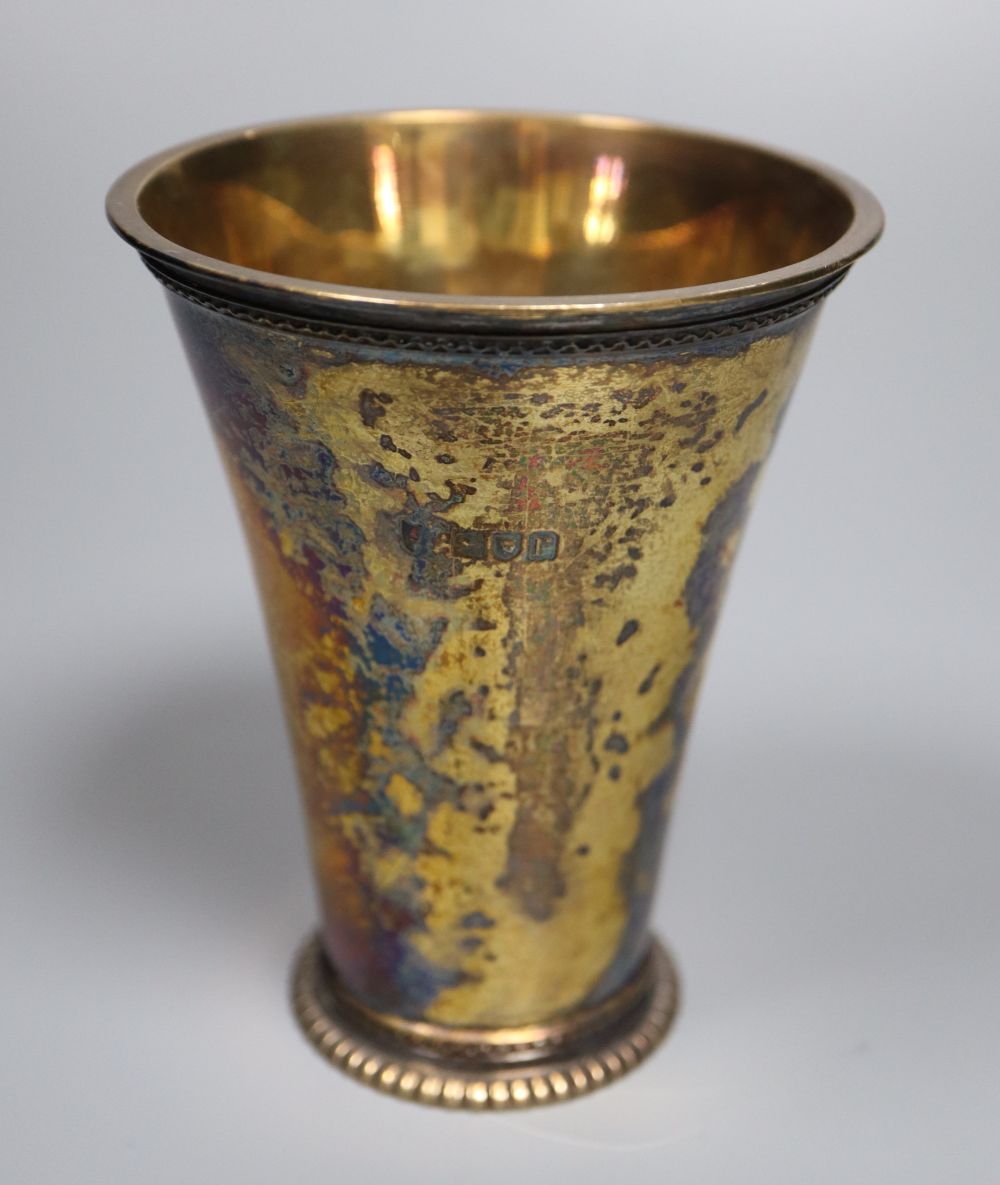 A George V silver gilt beaker, of flared form, Vander & Hedges, London 1912, 11.3cm, 6oz.